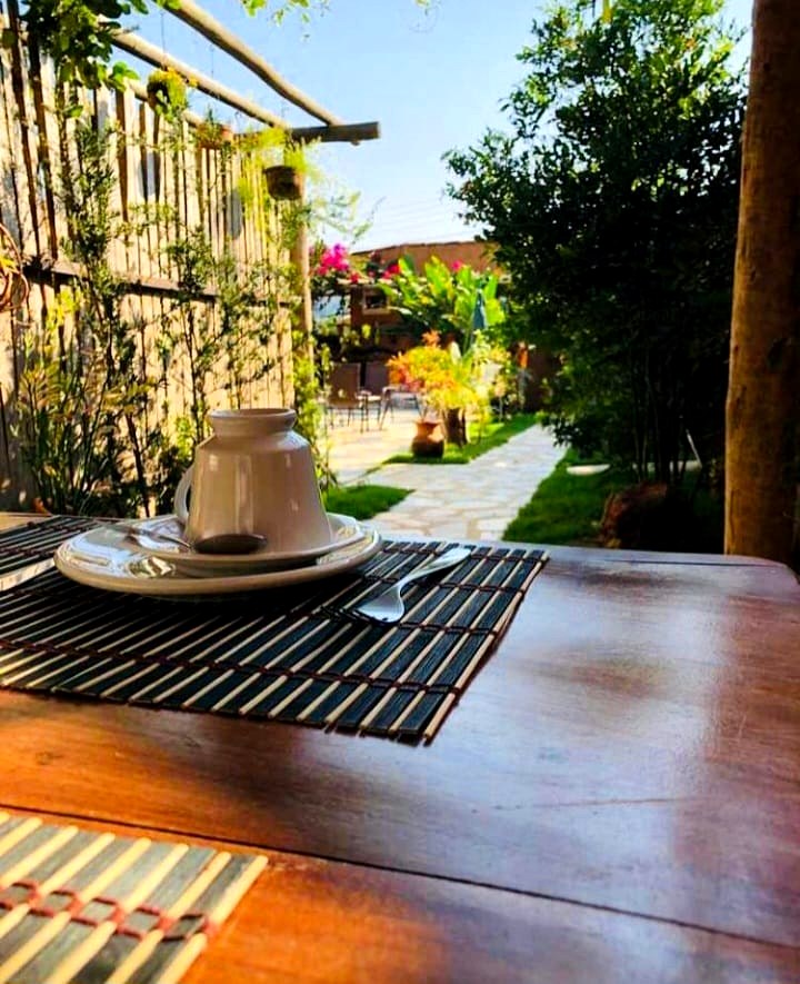Mesa com vista para o jardim da pousada